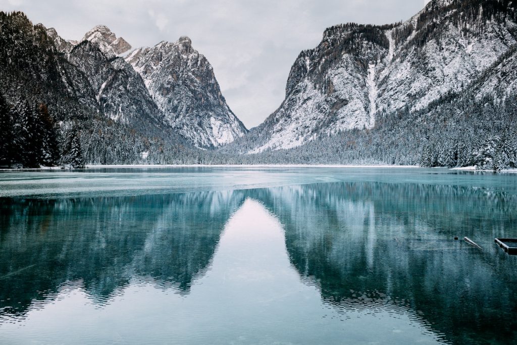 body of water and snow-covered mountains during daytime